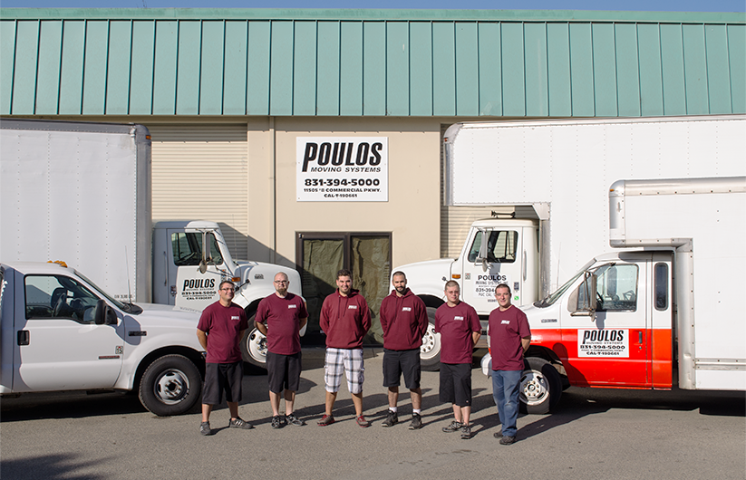 Poulos moving crew in front of office with moving trucks